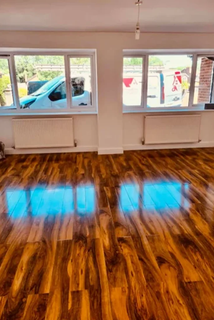 Wooden Garage Floor and wall with two radiators, and two windows above each radiator